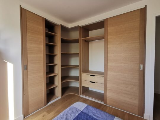 Dressing en chene avec coin arrondi et porte coulissante, barre de penderie et etagères reglables. 4 tiroirs en partie basse