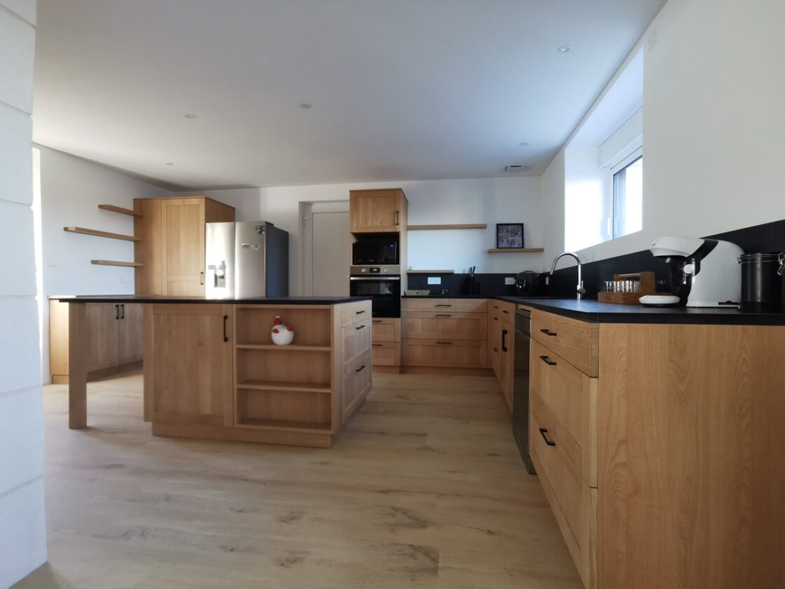 Cuisine contemporaine et moderne en chene massif et plan de travail compact ardoise avec electromenager et plaque aspirante