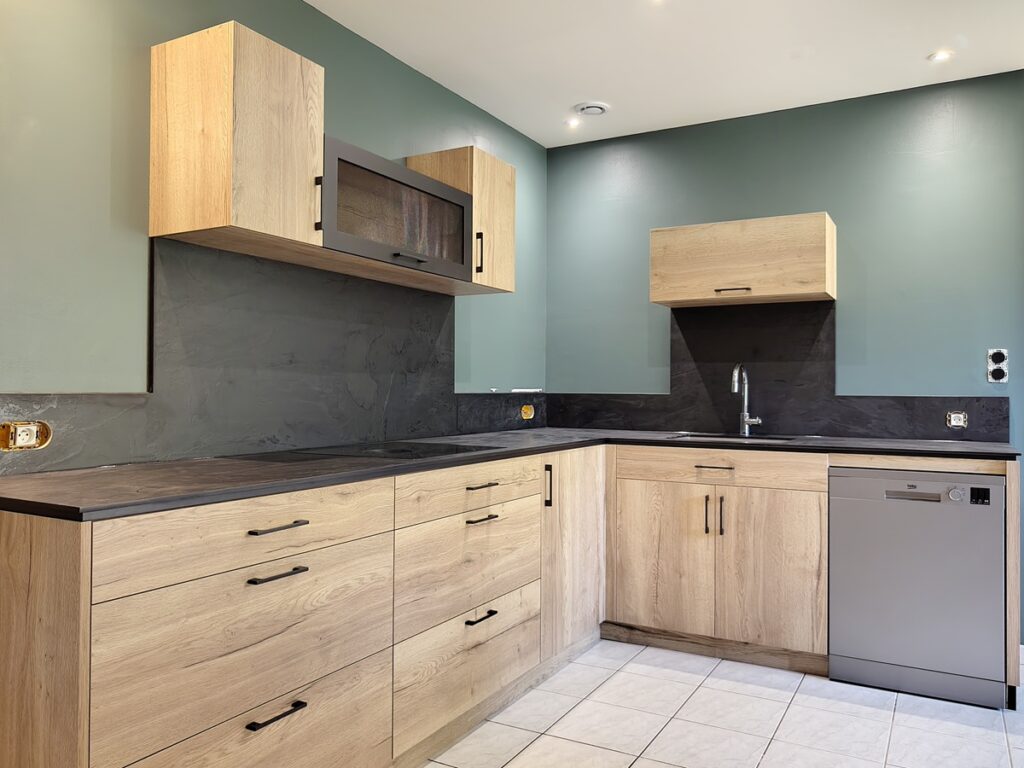 cuisine moderne en chene halifax et plans de travail et credence noir, avec ilot central table et espace colonne four